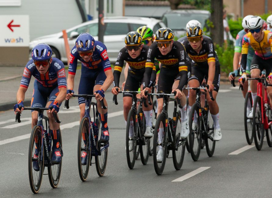 Group of cyclists racing on city streets during a competitive cycling event.